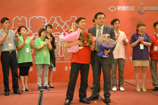 俞總懷抱證書（shū）和鮮花，與（yǔ）吳老師合影